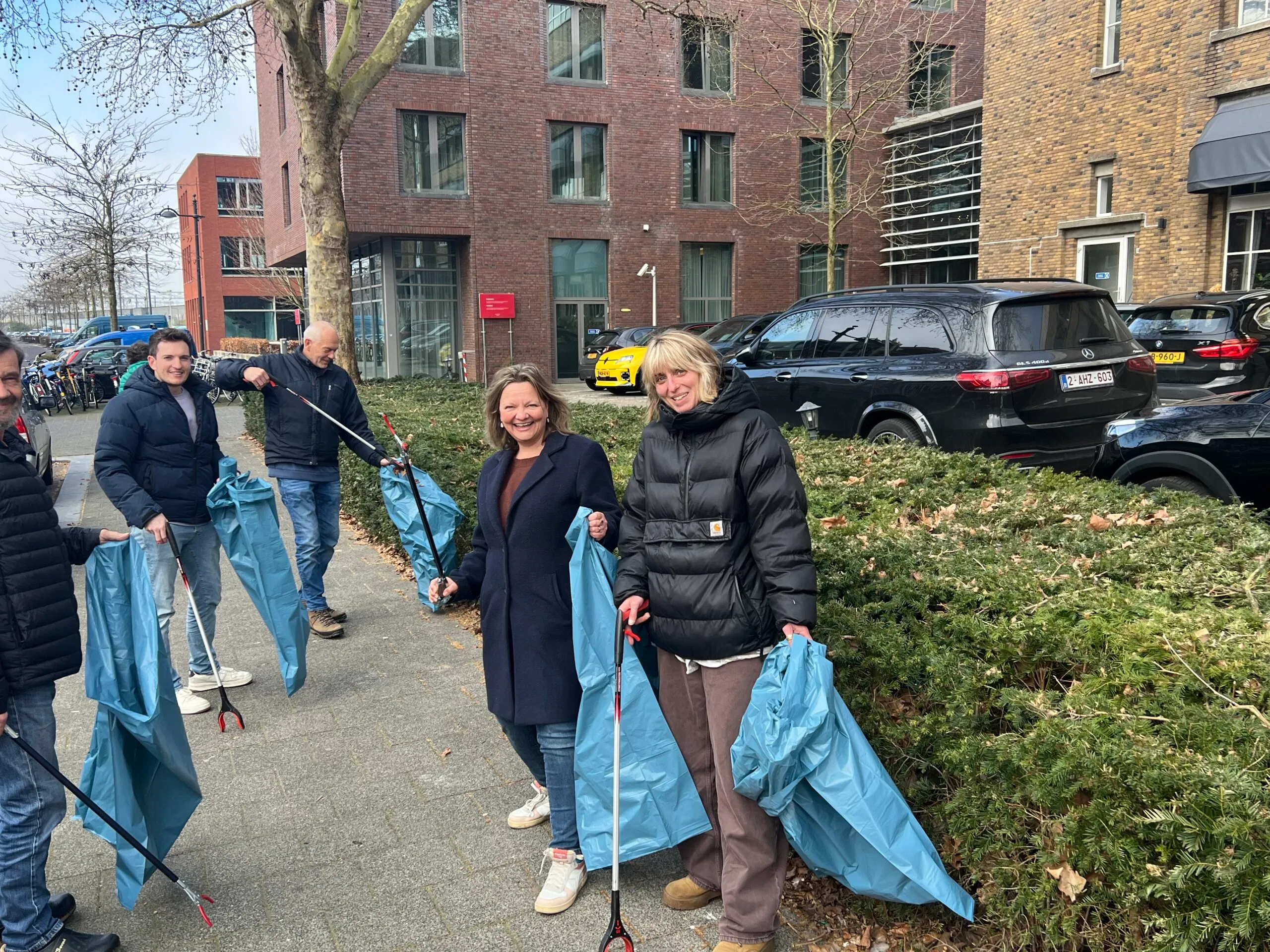 Bewoners ruimen samen zwerfafval op in het Stationskwartier Breda met grijpers en afvalzakken tijdens buurtopruimactie